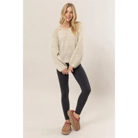 Cream-colored Melange Knit Sweater Pullover paired with black leggings and tan boots