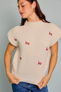 Cream-colored knit sweater with red ho text, perfect addition to women’s boho chic clothing