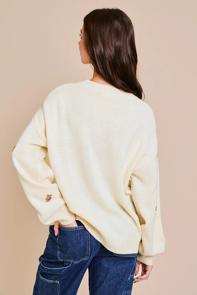 Cream-colored knit sweater featuring round neck long sleeve design, displayed from behind