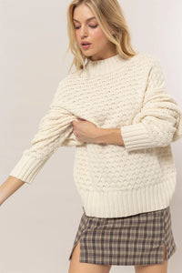 Cream-colored high neck knit sweater with textured pattern from Shop Daisy