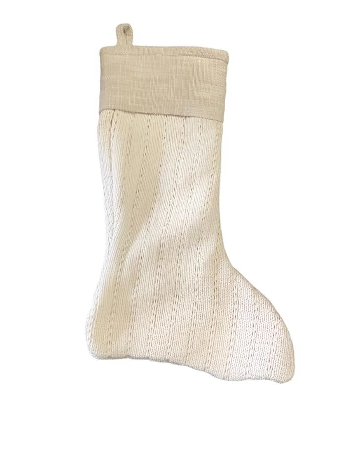 Cream-colored knitted Christmas stocking with fabric cuff for boho Christmas style