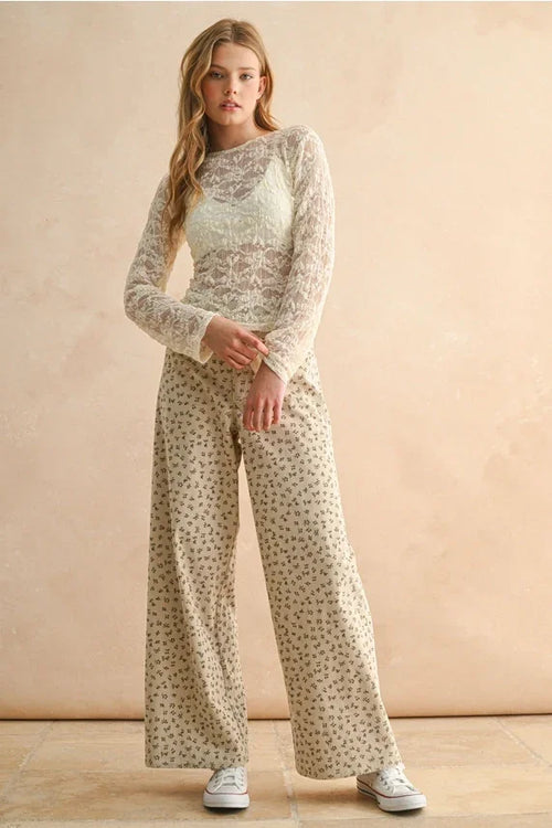 Cream-colored sheer lace top paired with floral printed corduroy pants for a stylish look