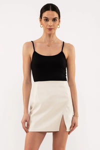 Cream-colored mini skirt with side slit and black spaghetti strap top from Shop Daisy