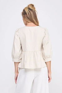 Cream-colored peplum blouse in textured cotton blend with three-quarter puff sleeves, back view