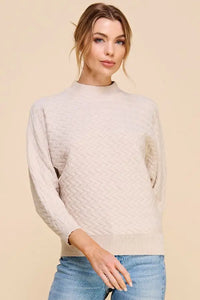 Cream-colored soft herringbone jacquard mock neck dolman sweater with long sleeves