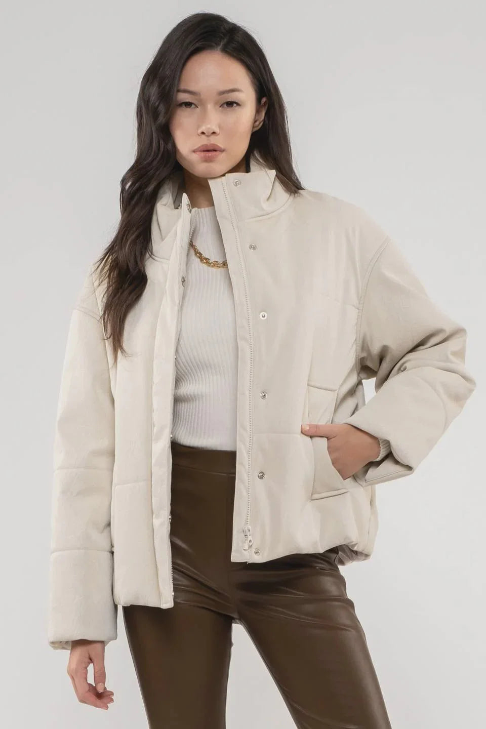 Cream-colored quilted puffer jacket with snap buttons, ideal for a Turtle Neck Faux Leather style