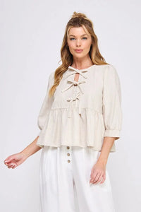 Cream-colored ruffled blouse in textured cotton blend with bow ties and three-quarter sleeves