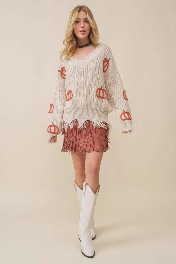 Cream-colored Pumpkin Patch V-Neck Frayed Sweater paired with skirt and white cowboy boots