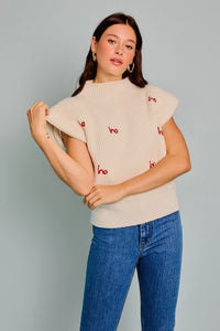 Cream-colored sweater with red heart designs and ruffled sleeves from Shop Daisy