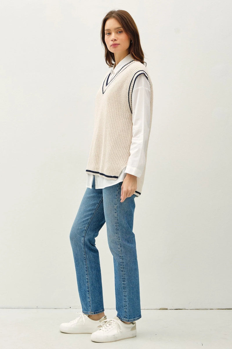 Cream-colored varsity style sweater vest with black accent stripe and V-neck design