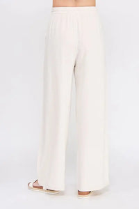 Cream-colored wide-leg embroidered linen pants with scallop trim for elegant style