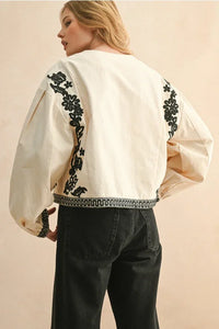 Cream floral patch detailed jacket with black patterns and white trim
