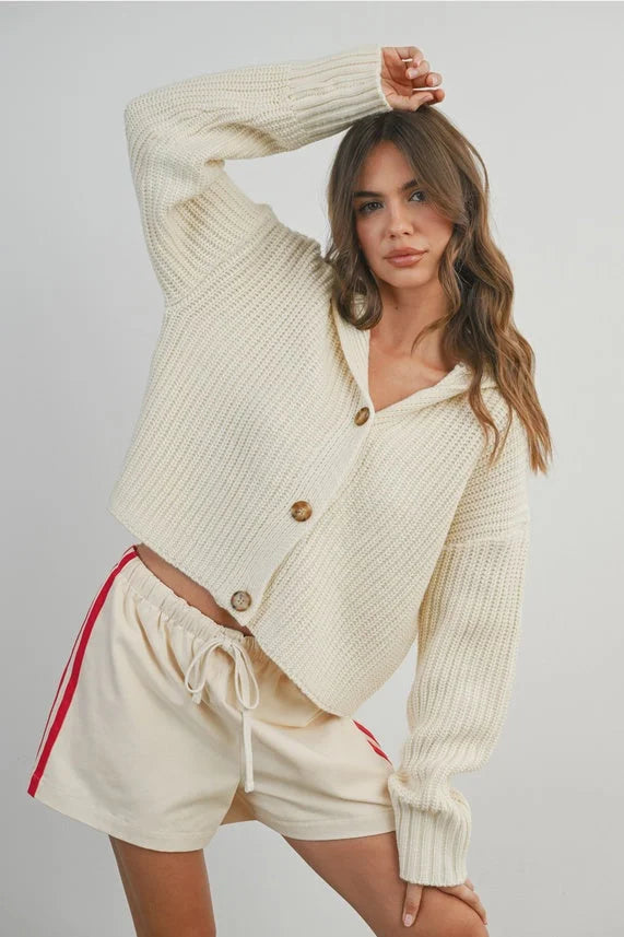 Cream knit collared v-neck long sleeve buttoned cardigan with red shorts
