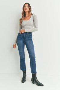 Cropped flare denim jeans styled with a grey long-sleeve top and black ankle boots