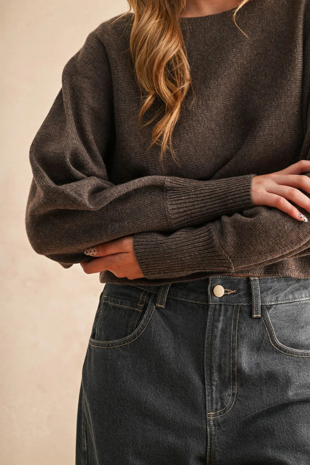 Dark brown knit boat neck sweater with ribbed cuffs paired with dark wash jeans