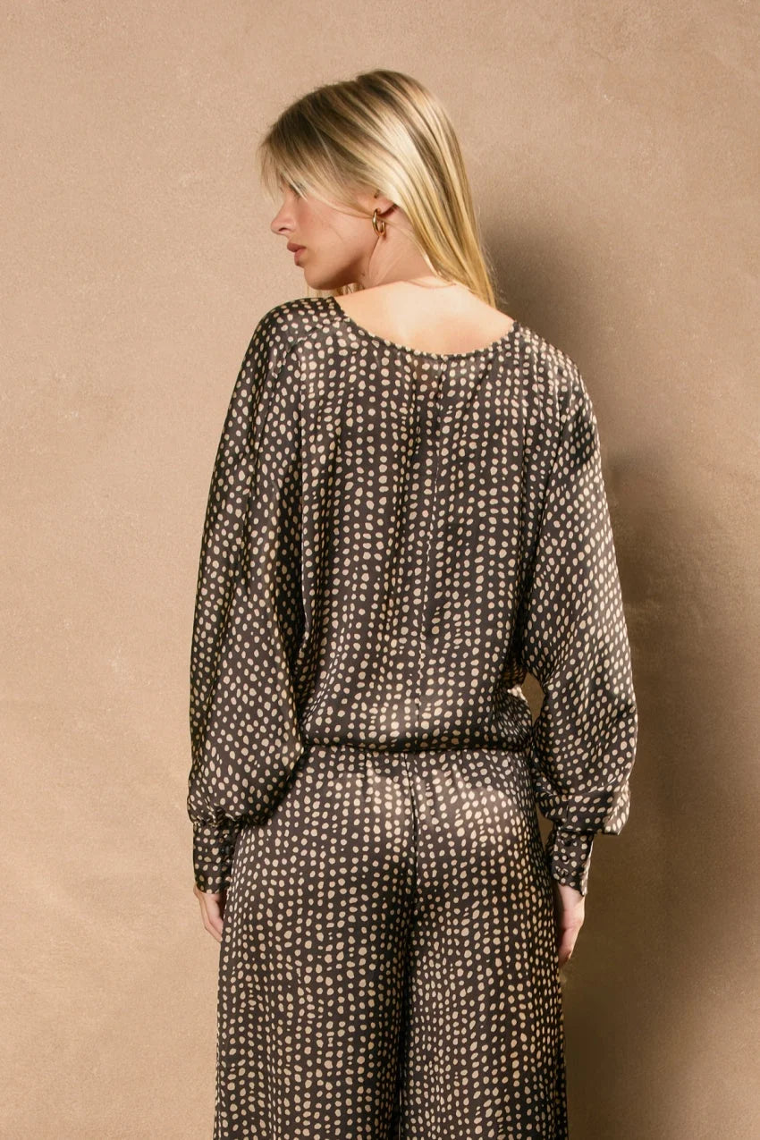 Dark-colored long-sleeved jumpsuit with light dotted pattern, perfect for women’s boho chic clothing from Shop Daisy