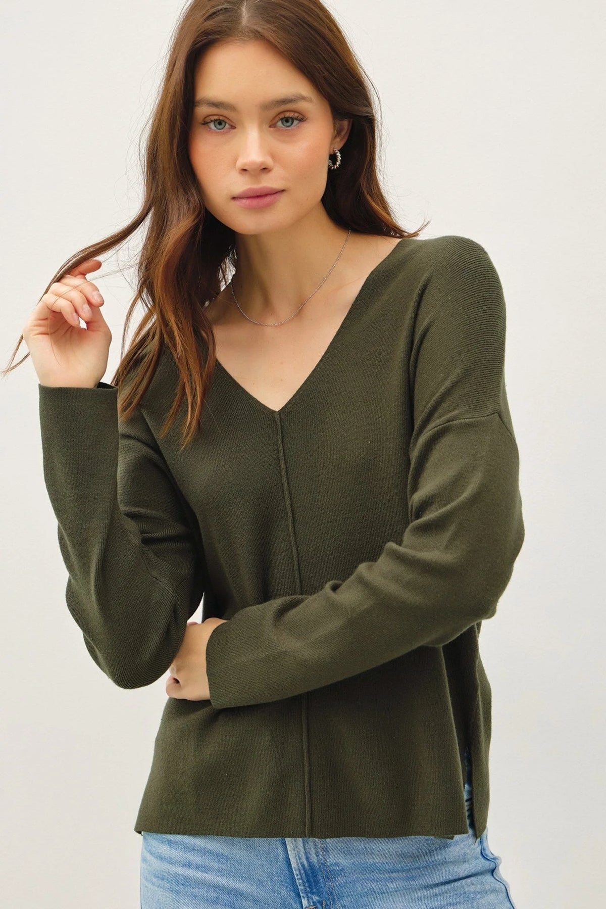 Dark green v-neck sweater with center seam, long sleeves for a boho, relaxed style