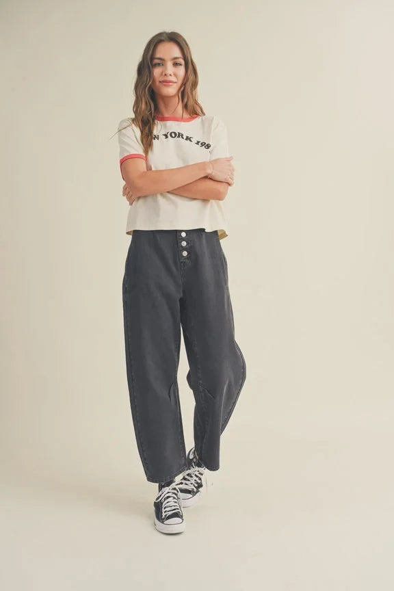 Dark high-waisted jeans with button-fly detail styled with a white graphic t-shirt