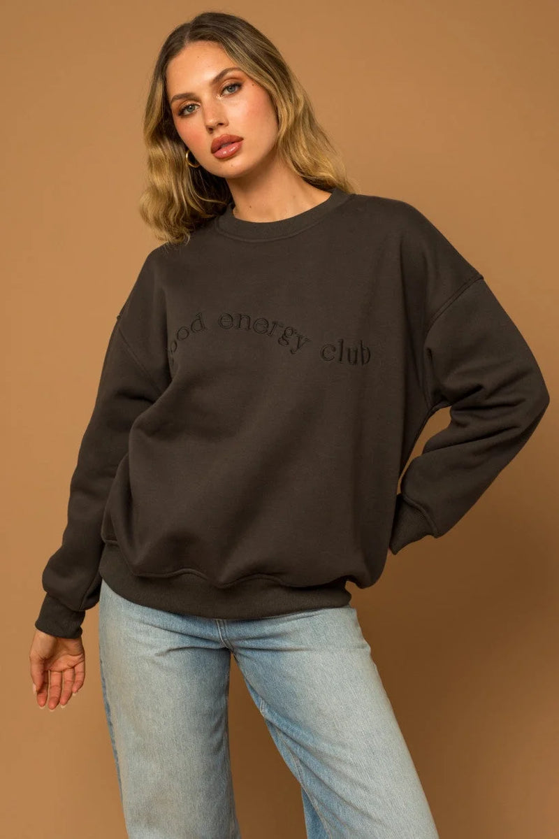 Woman with long blonde hair wearing a long sleeve round neck fleece sweatshirt