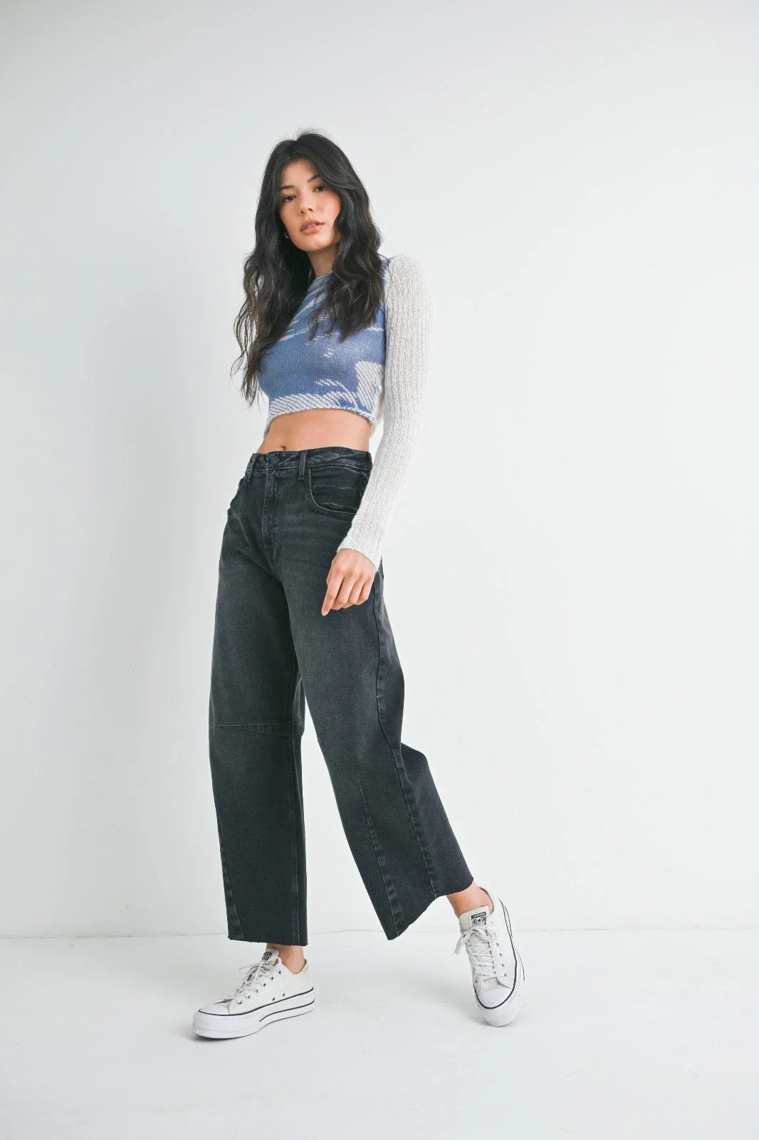 Dark wide leg denim jeans styled with a blue cropped top and white sneakers