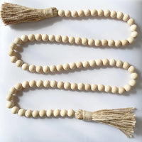 Beaded garland featuring natural wooden beads and jute tassels for rustic boho decor