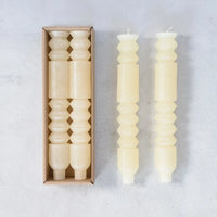 Decorative white unscented totem taper candles with geometric shapes and textures