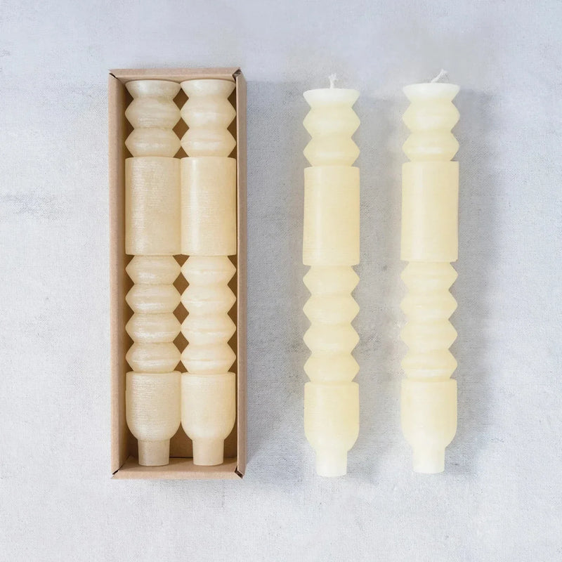 Decorative white unscented totem taper candles with geometric shapes and textures