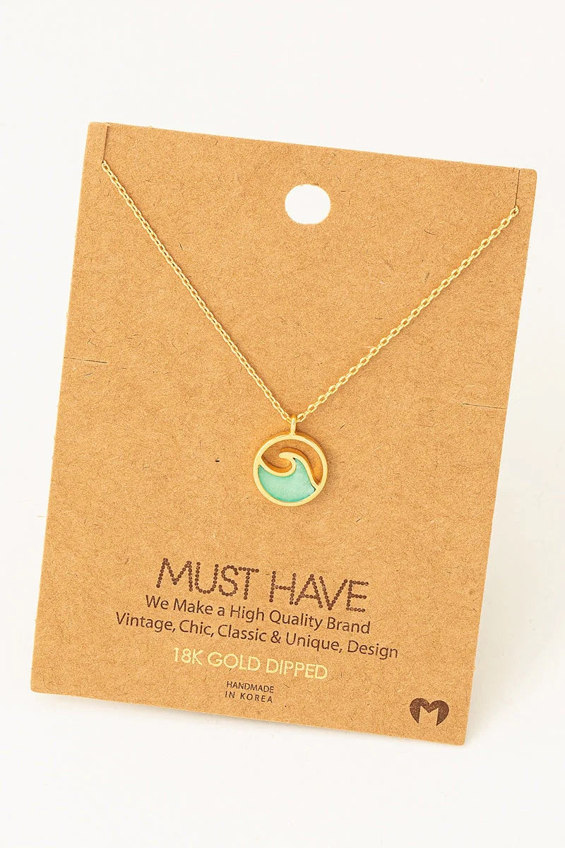 Delicate gold pendant necklace featuring a wave coin design with mint green accent