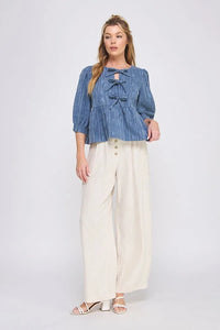 Denim peasant blouse with cream wide-leg pants showcasing a textured cotton blend