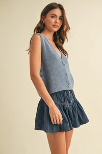 Sleeveless vest sweater with denim skirt, ruffled hem, button-down front