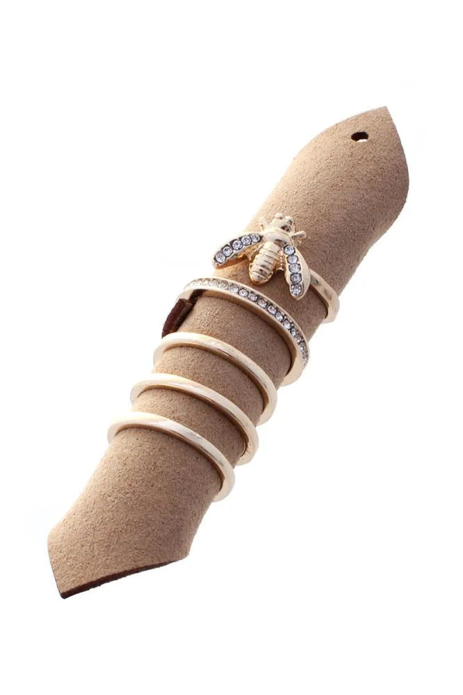 Diamond-encrusted bee ring on a beige suede holder from the Honey Bee Ring 5pc Set