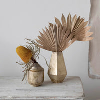 Dried natural Buri palm fan in a geometric vase with yellow flower in smaller vase