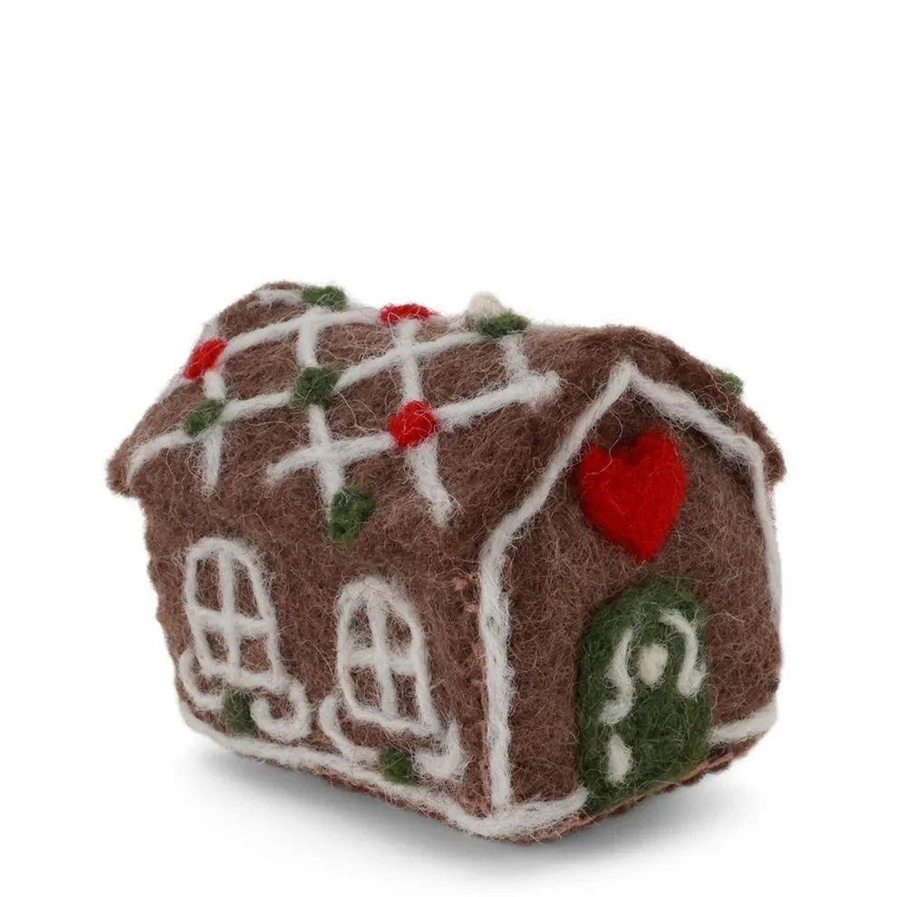 Handmade gingerbread house ornament with red heart, green door, and white icing