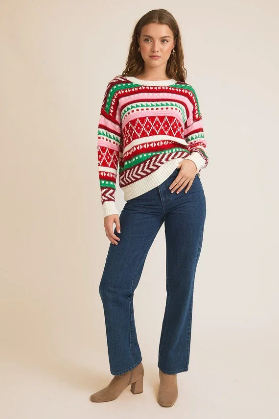 Festive red, white, and green round neck long sleeve colored Christmas sweater with blue jeans