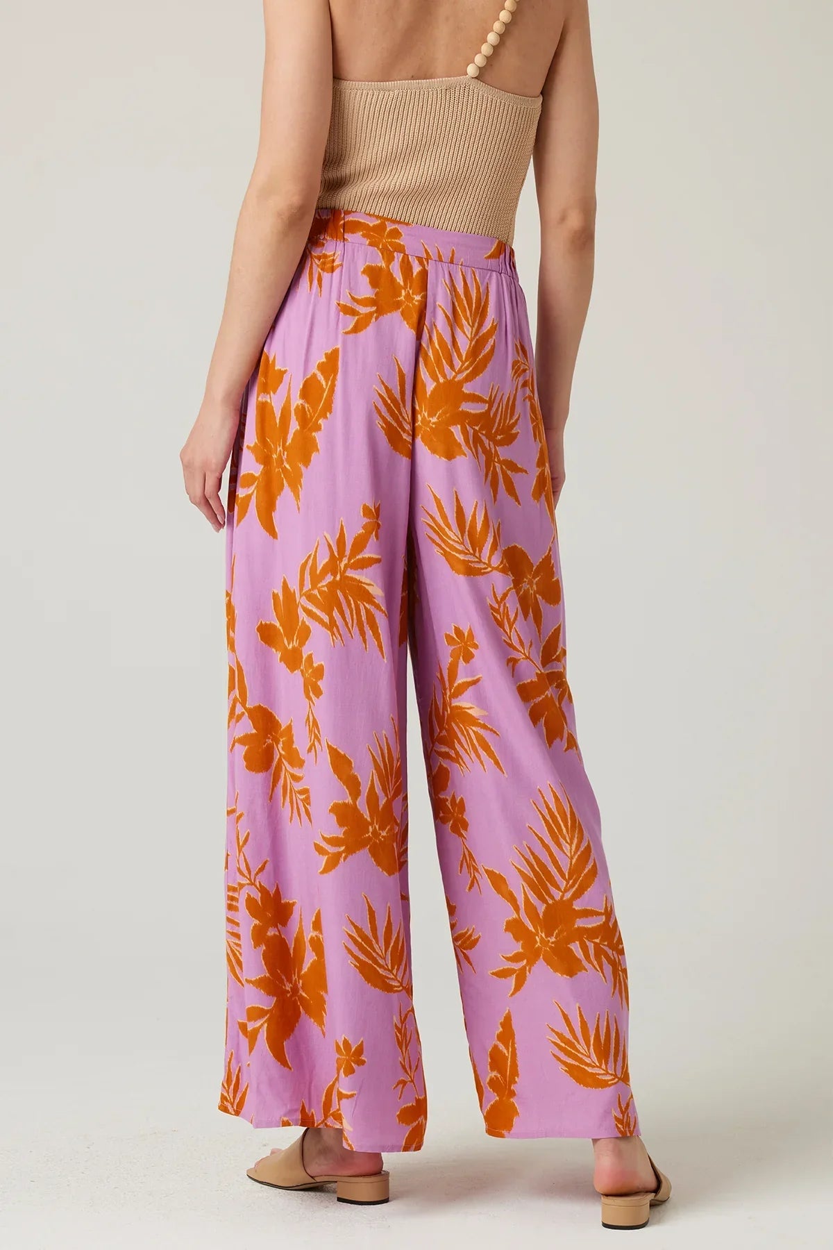 Flowy lavender wide-leg pants with vibrant orange tropical leaf print for a boho look