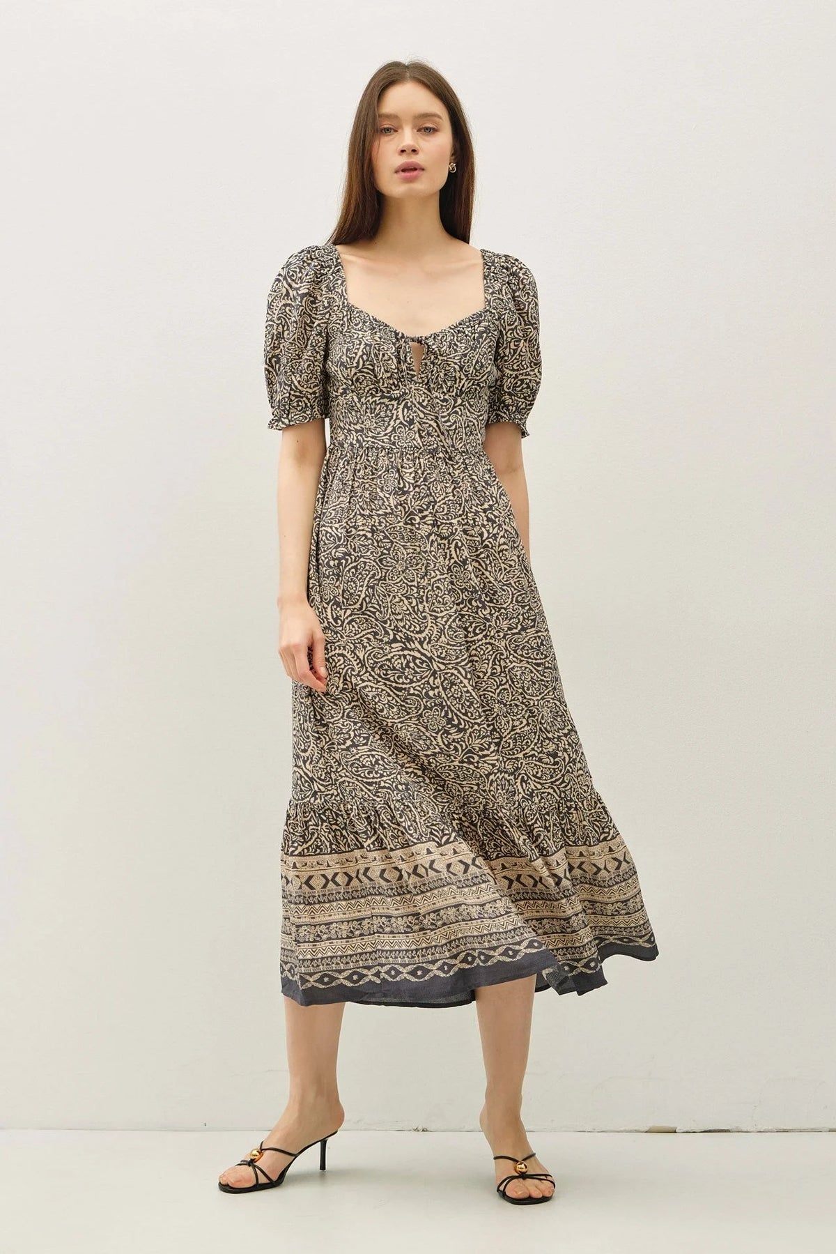 Elegant midi dress with paisley border print and puff sleeves, perfect for stylish occasions
