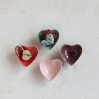 Four colorful stoneware heart shaped dishes in red, green, pink, and brown