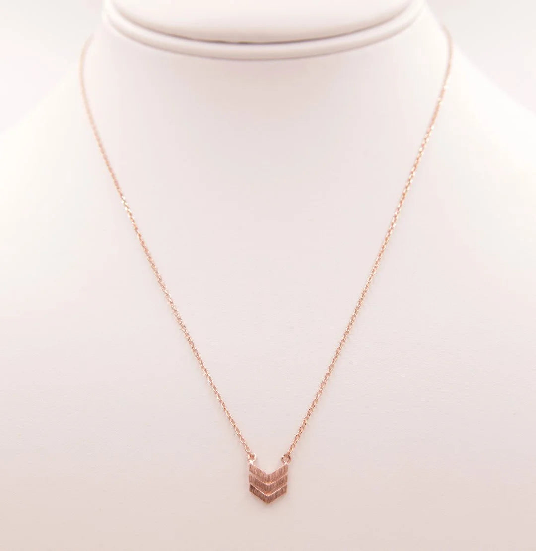 Gold arrow necklace showcased alongside the Dainty Heart Necklace for elegant style