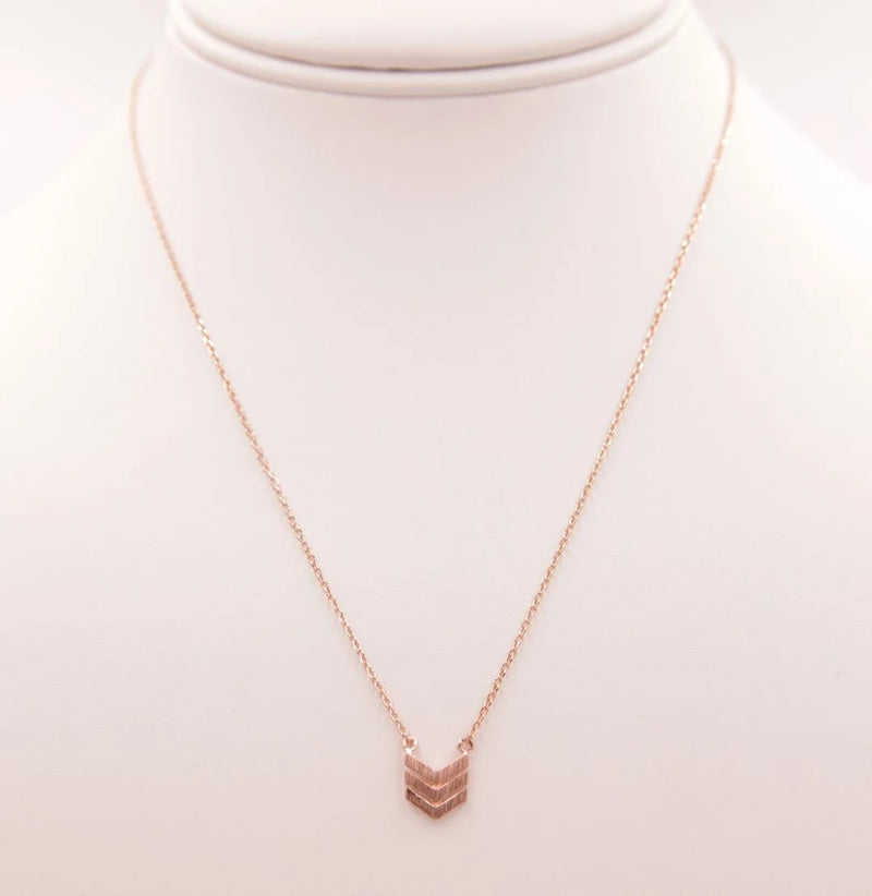 Gold arrow necklace showcased alongside the Dainty Heart Necklace for elegant style