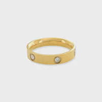 Gold band ring with embedded cubic zirconia, crafted in 18k gold for elegance