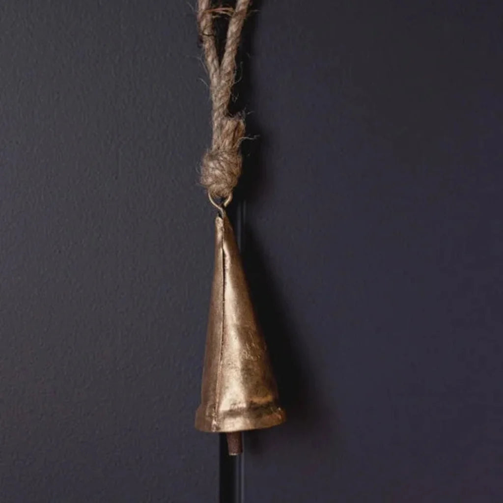 Tapered brass bell ornament with gold finish, rope handle, and black stick