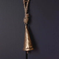Tapered brass bell ornament with gold finish, rope handle, and black stick