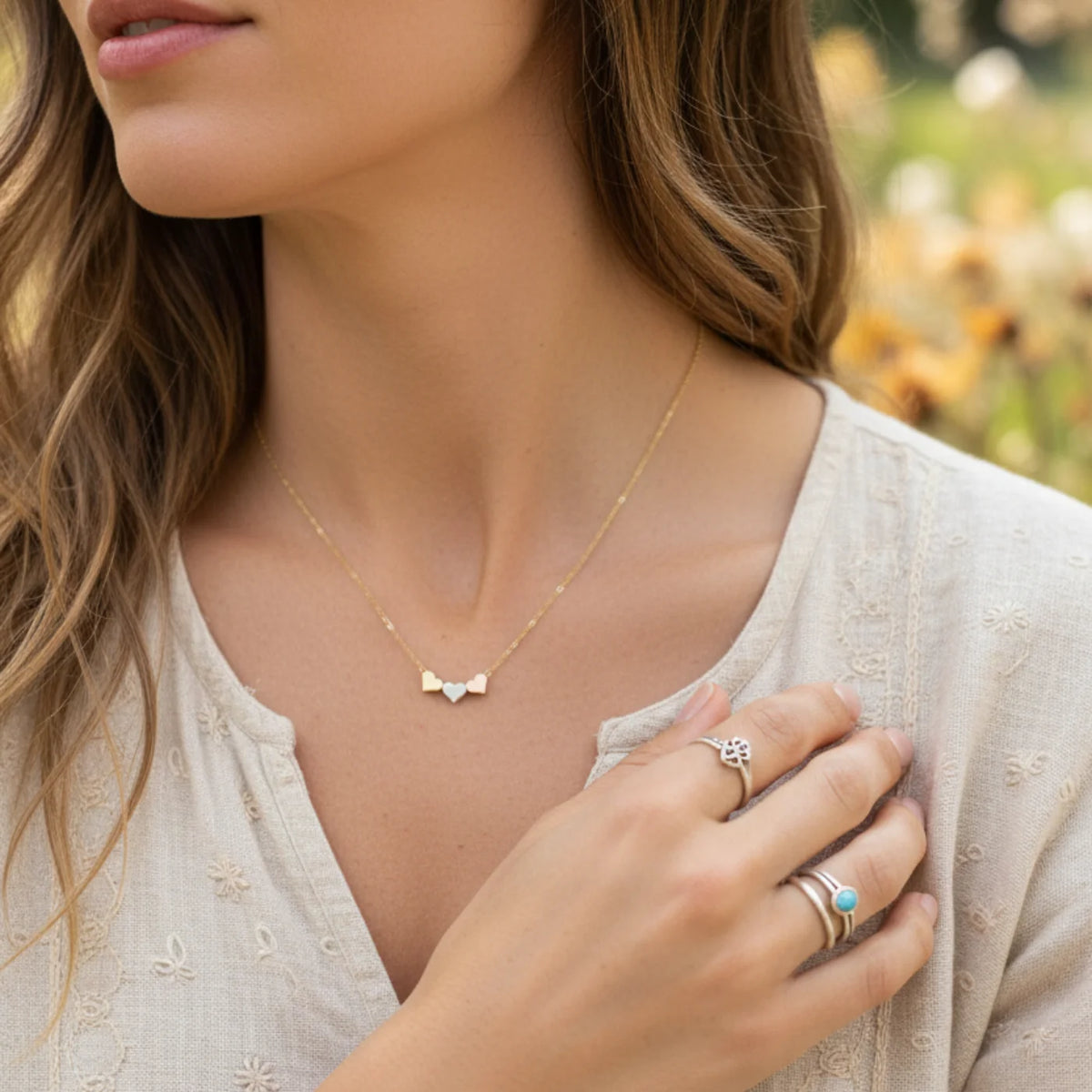 Three tone dainty hearts necklace with gold bow design