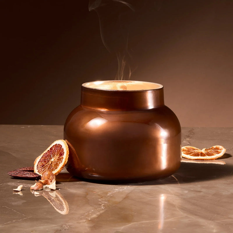 Gold ceramic pot with steam and dried citrus slices, embodying Embers Autumn Glow Signature Jar Candle