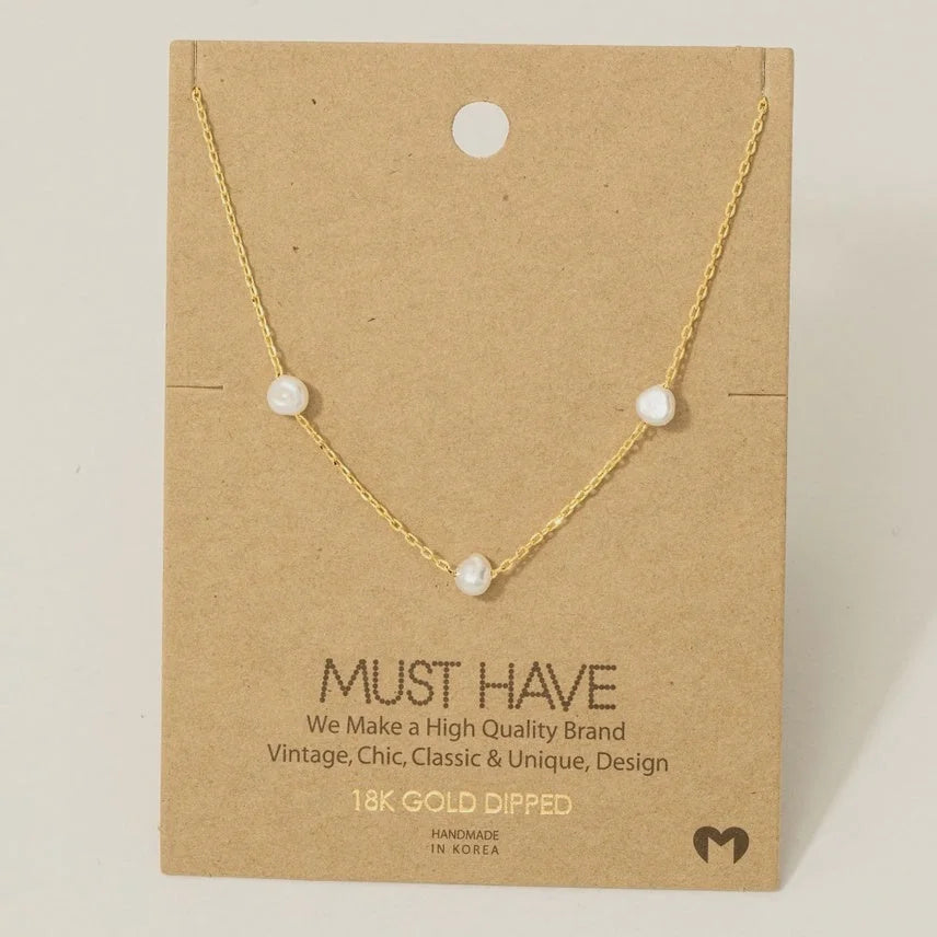 Gold dipped dainty three pearl charm necklace featuring a gold dipped dainty three pearl design