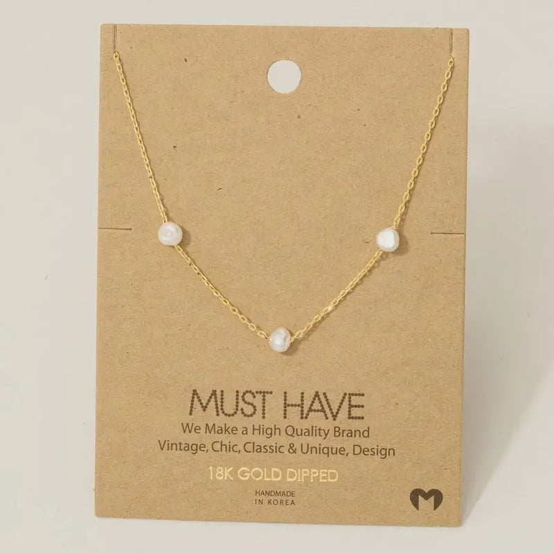 Gold dipped dainty three pearl charm necklace featuring a gold dipped dainty three pearl design