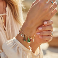 Classic Christmas charm bracelet with gold chain, red green tree pendants, pearl bead, snowflake, silver rings