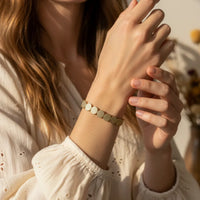 Matte gold tone textured disc stretch bracelet with woven design