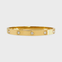 Gold-colored bangle bracelet with clear cubic zirconia accents and water resistant cubic zirconia