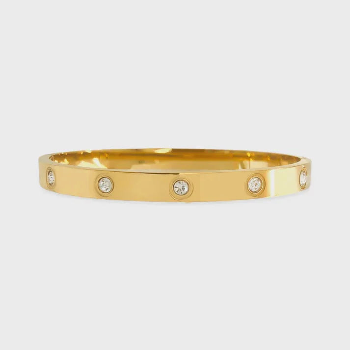 Gold-colored bangle bracelet with clear cubic zirconia accents and water resistant cubic zirconia